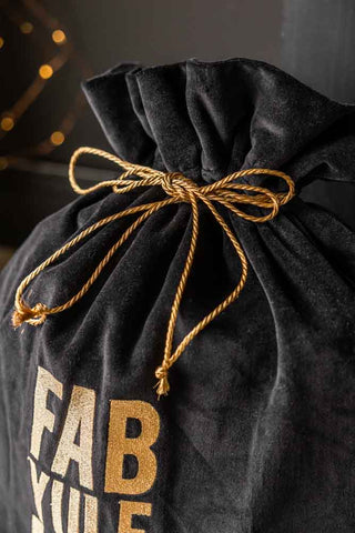 Close-up of the top of the Fab Yule Us Velvet Christmas Sack, with the cord tied into a bow.