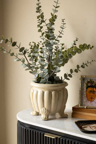 Lifestyle image of the Faux Eucalyptus Plant In Pot agaisnt light background