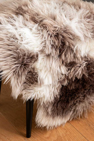 Close-up of the Faux Sheepskin Rug in White & Walnut on a bench.