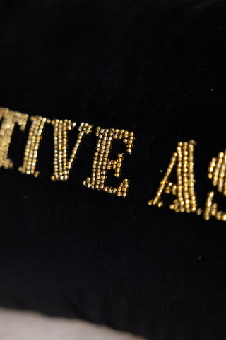 Detail shot of the beaded text on the Festive As Fuck Christmas Cushion.