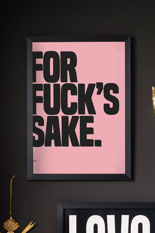 The For Fuck's Sake Pink & Black Art Print - Unframed styled in a frame on a black wall with another art print and some wall ornaments. 