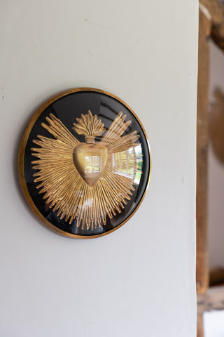 The Framed Golden Milagro Heart Decoration on a white wall.