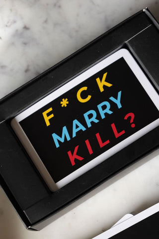 The Fuck, Marry, Kill Card Game displayed on a white marble surface in its box.