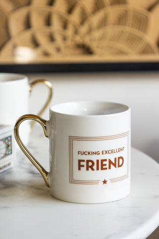 A white mug with rust / gold coloured detailing and the statement, 'F*cking Excellent Friend' written on it 