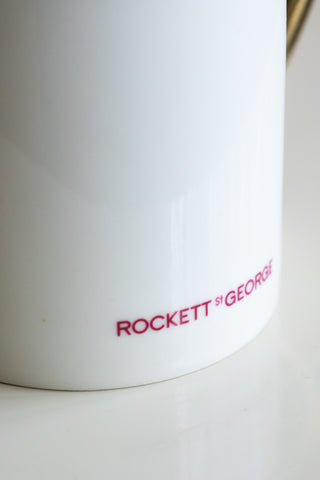 A close-up of the Rockett St George logo on a white mug