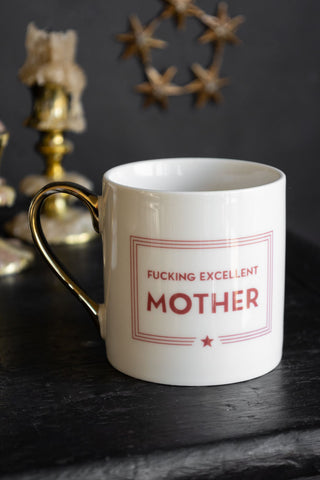 A white mug featuring red detailing and the statement, 'F*cking Excellent Mother' written on it 