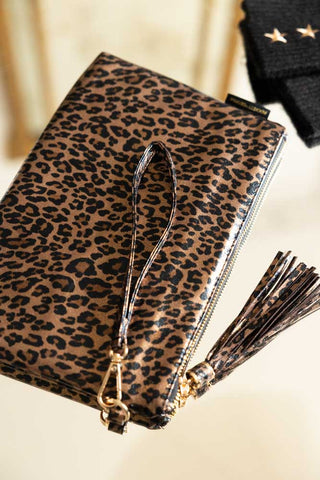 The Glam Leopard Print Clutch Bag displayed on a table with some handwarmers in the background.