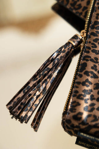 Close-up of the tassel zip of the Glam Leopard Print Clutch Bag.