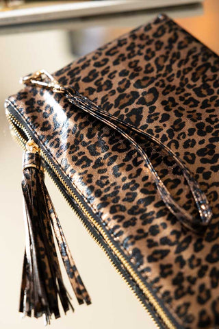 Close-up of the Glam Leopard Print Clutch Bag displayed on a table.