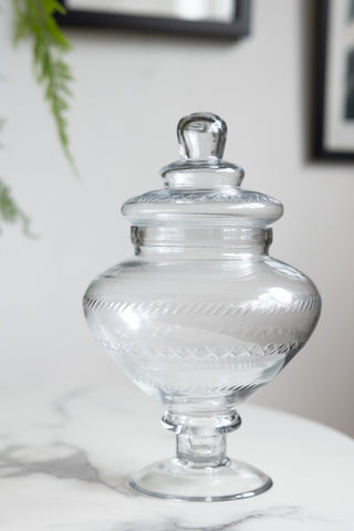 The Glass Footed Jar displayed on a white table.