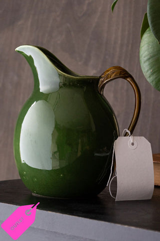 Green glazed outlet jug with a pink tag that says 'outlet'