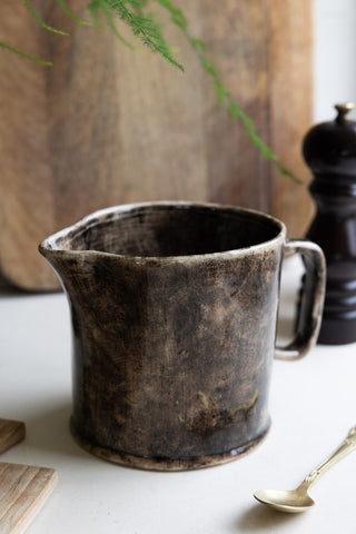 Mottled brown jug styled on a white kitchen worktop.