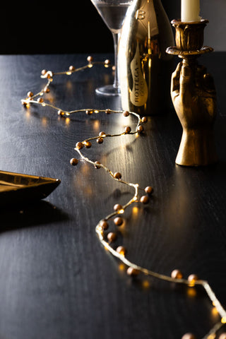 A gold berry style fairy light in the middle of the table.