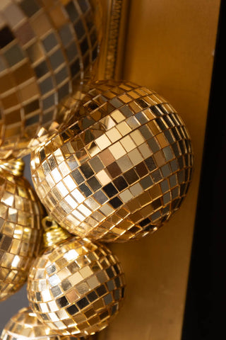 Detail shot of the Gold Disco Ball Cluster Christmas Decoration displayed on the edge of a frame.