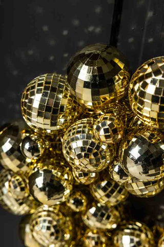 Close-up of the Gold Disco Ball Wreath hanging on a black door.