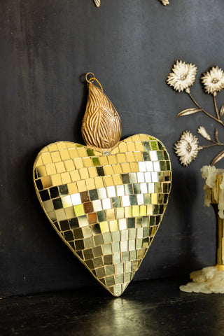 The Disco Ball Flaming Heart Decoration styled on a black unit with some candlestick holders and floral decorations.