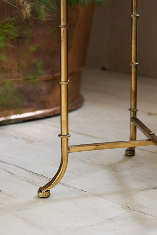 Detail shot of the leg of the Gold Distressed Mirrored Side Table.