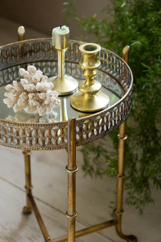 Detail shot of the Gold Distressed Mirrored Side Table seen from above, styled with various accessories and plants.