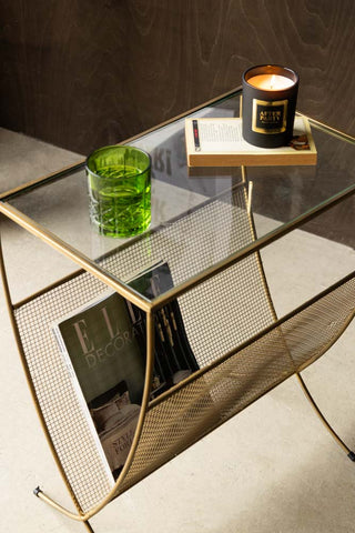 Gold Magazine Rack With Glass Top styled with candle and glass on top