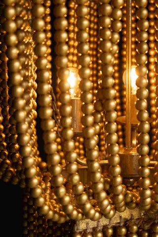 Close-up of the beads on the Gold Star Shaped Beaded Statement Chandelier Light, showing the lit bulbs inside.