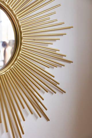 Detail shot of the starburst design of a round wall mirror.