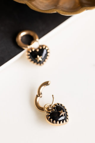 The Gold & Black Heart Huggie Hoop Earrings on a neutral background, with one of the hoops open.