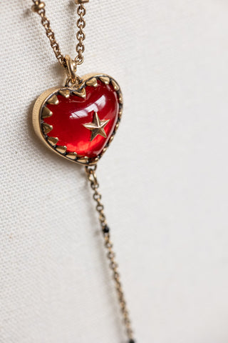 Close-up of the heart on the Gold & Red Heart & Star Layered Chain Necklace.