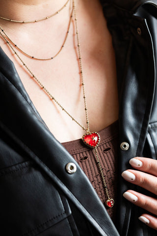 The Gold & Red Heart & Star Layered Chain Necklace being worn by a model.