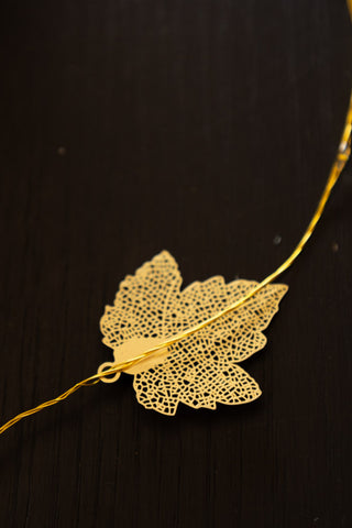 Golden leaf hanging on a light chain. 