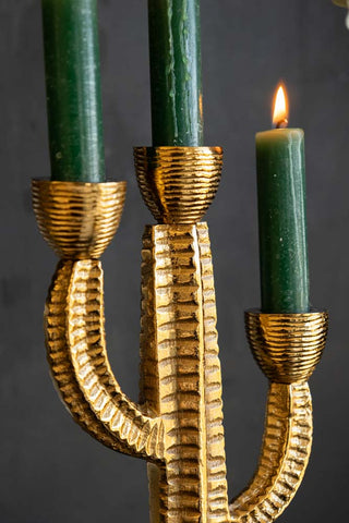 Close-up of the Gorgeous Gold Cactus Candle Holder with lit green candles inside.