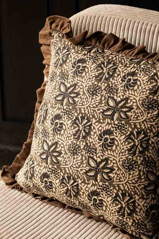 Close-up of the Green Floral Ruffle Edge Cushion on a chair.