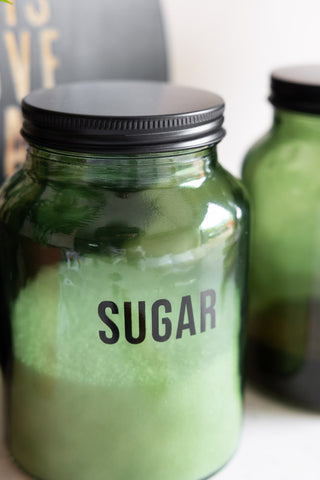 Close-up of the Green Glass Storage Jar With Black Lid - Sugar.