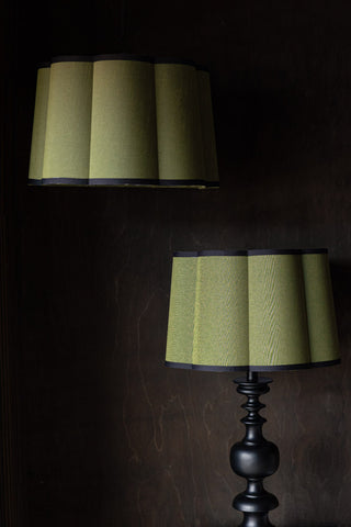 Two Green Scalloped Easyfit Lampshades, one styled on a lamp base and one styled as a pendant light, in front of a dark wall.