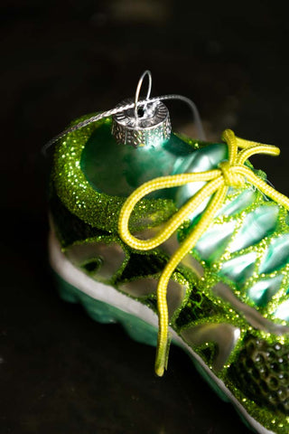 Detail shot of the Green Trainer Christmas Tree Decoration on a dark background.