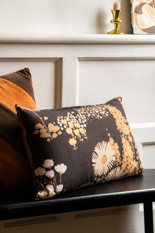 The HKLiving Dark Florals Cotton Cushion styled on a bench with another cushion.