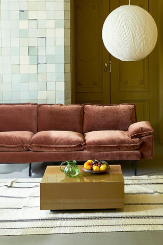 The HKliving Retro 3 Seater Sofa in Magnolia Velvet styled with a rug, coffee table, pendant light, fruit bowl and glass jug.