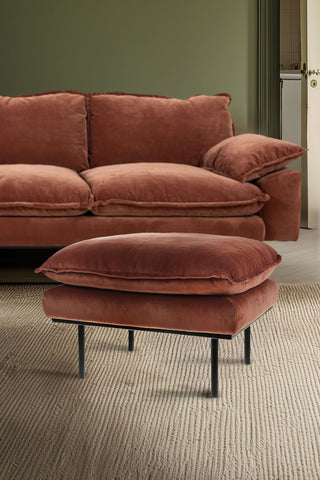 The HKliving Retro Footstool in Magnolia Velvet, styled on a rug in front of the matching sofa.