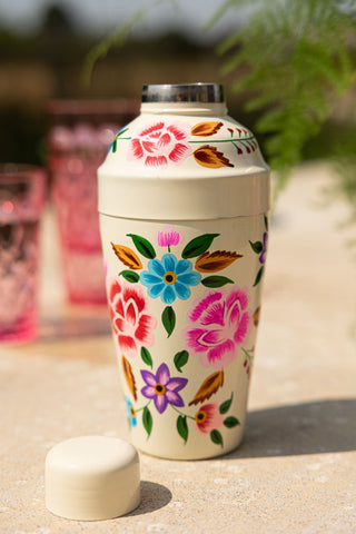 The Hand Painted Floral Detail Cocktail Shaker on an outdoor table with the lid off.