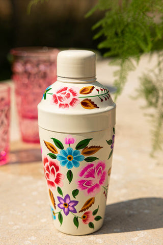 The Hand Painted Floral Detail Cocktail Shaker displayed on an outdoor table.