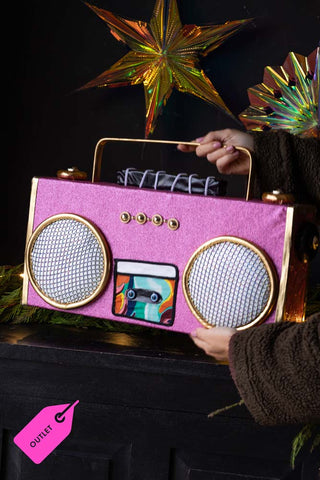 A pink boombox decoration being held in someones hands, with a pink tag that reads: 'outlet'.