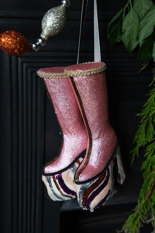 The Handmade Groovy Spiral Platforms Decoration hanging in front of a metal fireplace with greenery