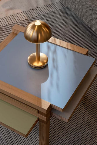 The Humble - Domed Cable-Free Mood Lighting Lighting in Gold displayed on a side table.