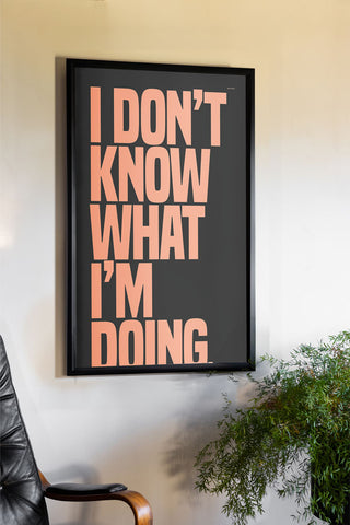 The I Don't Know What I'm Doing Art Print - Unframed styled in a black frame on a neutral wall, above a desk chair and a plant.