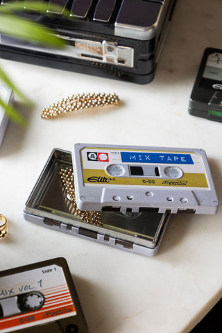 The I Made You A Mix Tape Cassette Tape Storage Tin with the lid off, styled with various accessories, other tins and a plant.