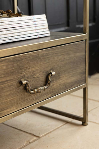 Close-up of the drawer of an industrial style bedside table, with a stack of magazines on the shelf above.