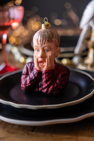 The Kevin Inspired Christmas Tree Decoration styled on a stack of plates as part of a Christmas table.