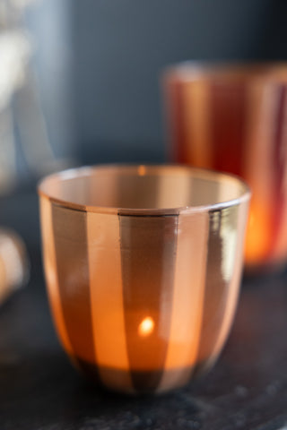 Close-up of the Khaki Striped Tealight Holder - Short, styled with a lit tealight inside.