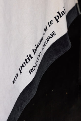 Detail image of the text on the Kiss Me Beach Towel.