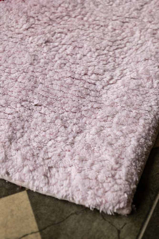 Detail shot of the corner of the LOVE Tufted Cotton Bath Mat.