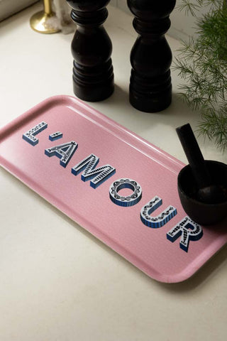 The L'amour Pink Tray styled in a kitchen with a pestle and mortar, salt and pepper grinders and a plant.